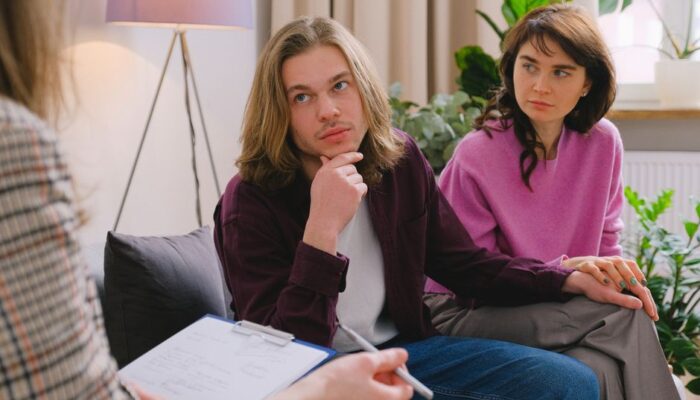 A couple holding hands during a therapy session in an office setting. - Photo by SHVETS production on Pexels