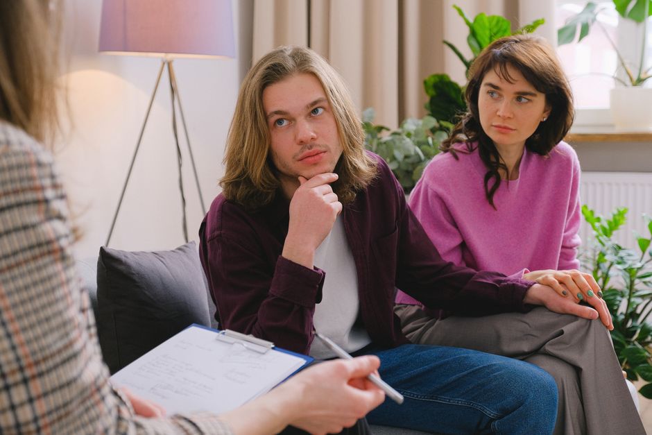 A couple holding hands during a therapy session in an office setting. - Photo by SHVETS production on Pexels