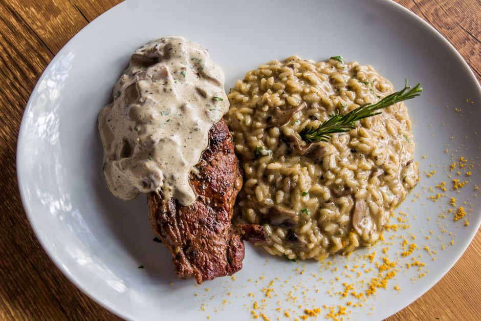 Delicious steak topped with sauce served with creamy mushroom risotto. Italian cuisine on a white plate. - Photo by Vinícius Caricatte on Pexels