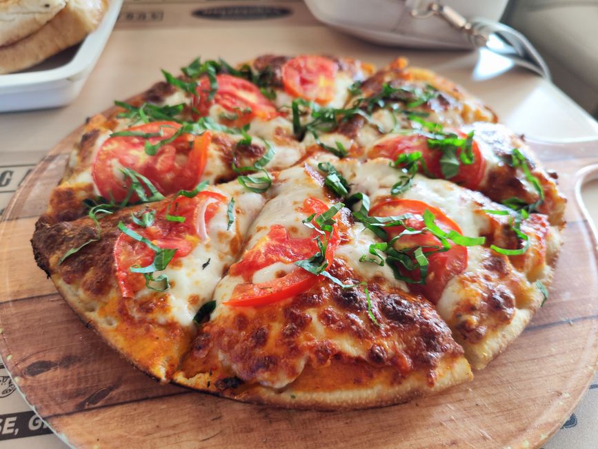 Close-up of a fresh Margherita pizza with tomatoes and basil. Perfect for Italian cuisine promotions. - Photo by Sonali Mehta on Pexels